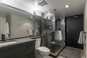 Modernt hotellbadrum med glasdusch, kakel och fristående toalett