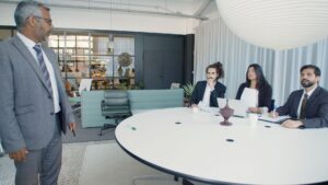 Möte i konferensrum med fyra personer runt ett stort bord
