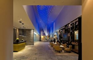 Modern hotellobby med blå takbelysning och varm loungemiljö