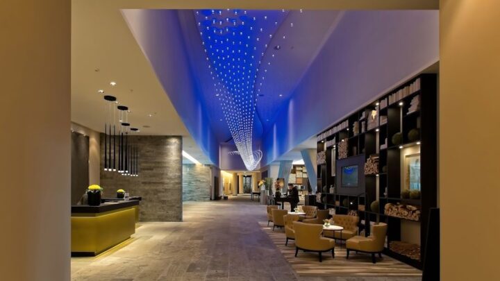 Modern hotellobby med blå takbelysning och varm loungemiljö