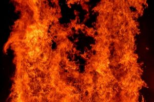 Intensiva orange och röda lågor fyller bilden, med mörka partier i bakgrunden.