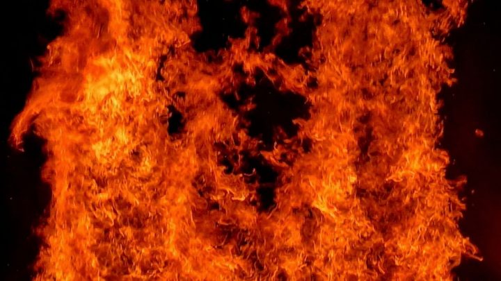 Intensiva orange och röda lågor fyller bilden, med mörka partier i bakgrunden.